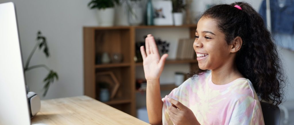 Girl waving facing laptop camera