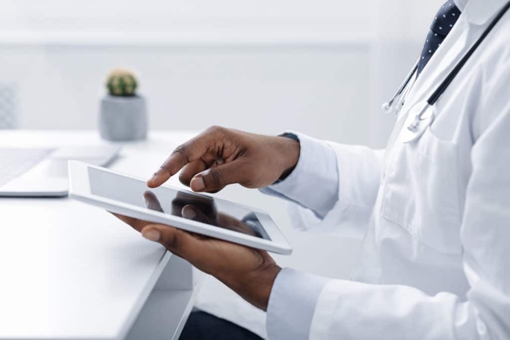 Cropped of doctor using slack in digital tablet at workplace